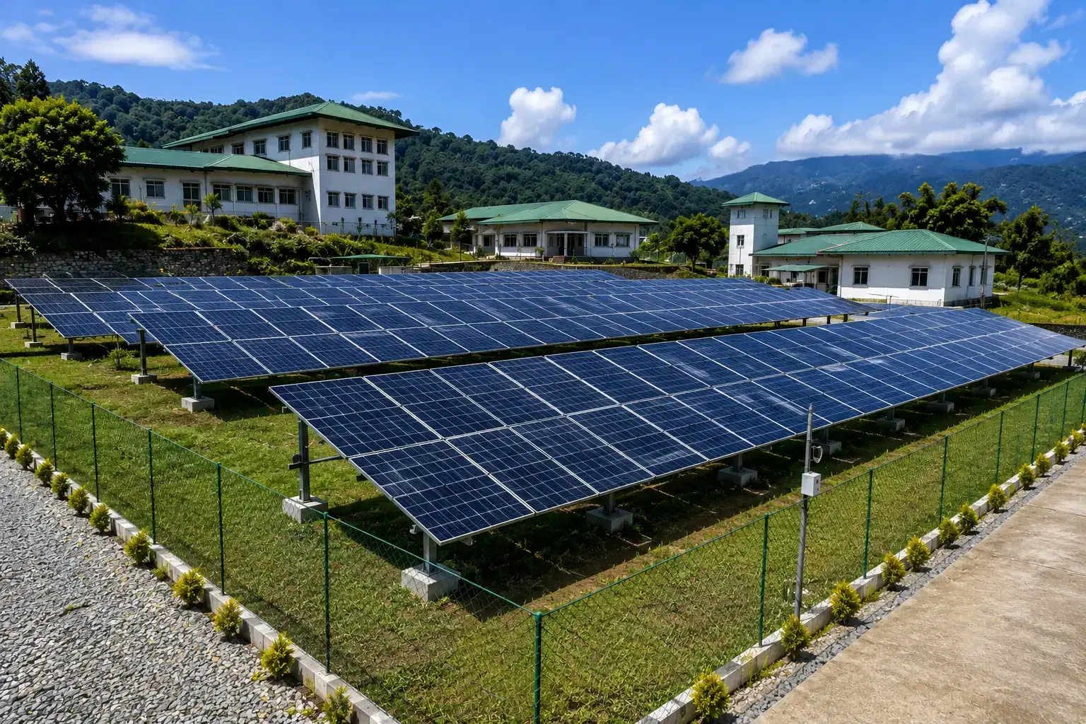 Fenced ground-mounted solar array on a hillside institutional campus