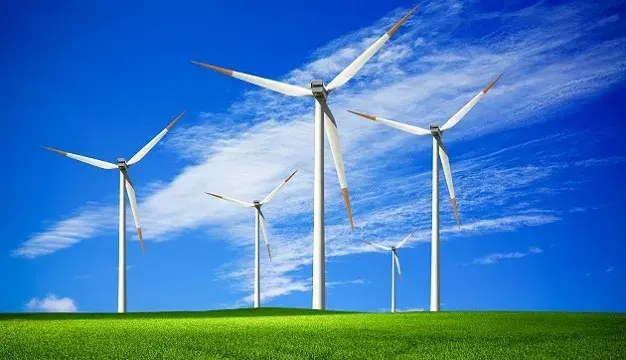 Wind turbines across open grassland under a clear sky
